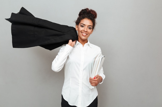 Free photo young african business woman standing over grey wall