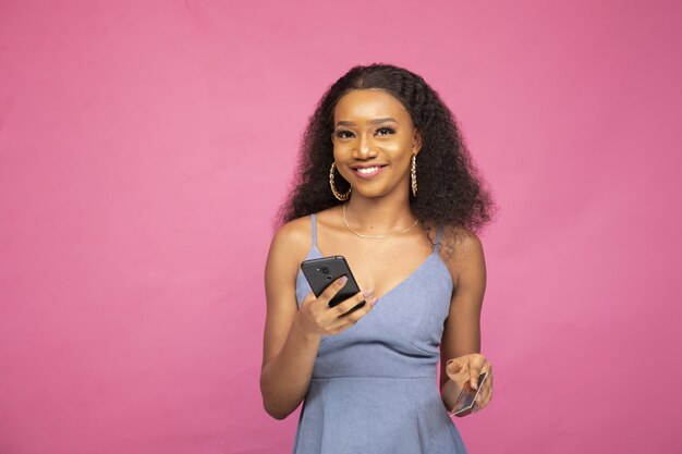 그녀의 스마트 폰과 신용 카드를 사용하여 온라인으로 구매하는 젊은 아프리카 여성