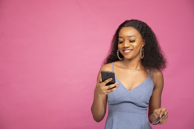 Young African female shopping online using her smartphone