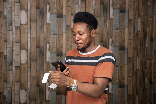 Молодой африканский мужчина фотографирует слип с помощью своего смартфона