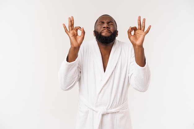 Free photo young african man in bathrobe prepare for skin care showing ok finger sign human emotions concept