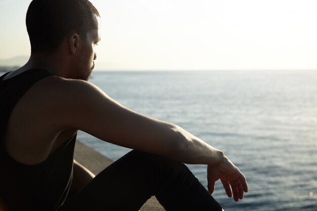 Young African man contemplating amazing landscape of calm sea