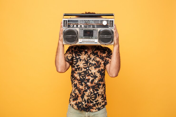 Free Photo young african man covering face with tape recorder