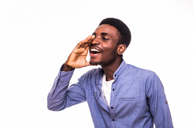 Young african man screaming out loud isolated on white wall