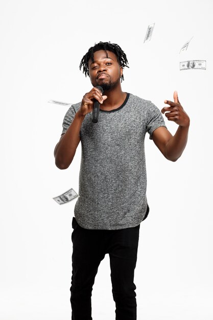 Young african man singing in microphone on white.