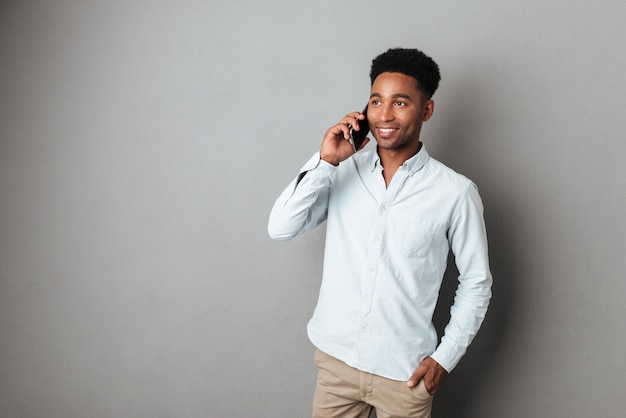 Giovane africano parlando sul cellulare mentre in piedi