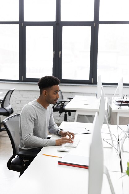 Young african office worker sitting at a desk