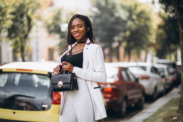 거리 밖에 서 흰 양복을 입은 젊은 아프리카 여성