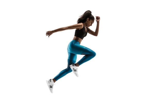 Young african woman running isolated on white studio background. One female runner or jogger. Silhouette of jogging athlete