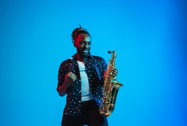 Young africanamerican jazz musician playing the saxophone