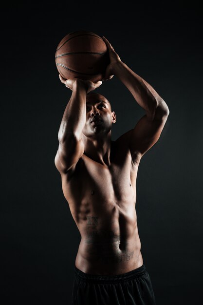 Young afro american basketball player preparing to throw ball in basket