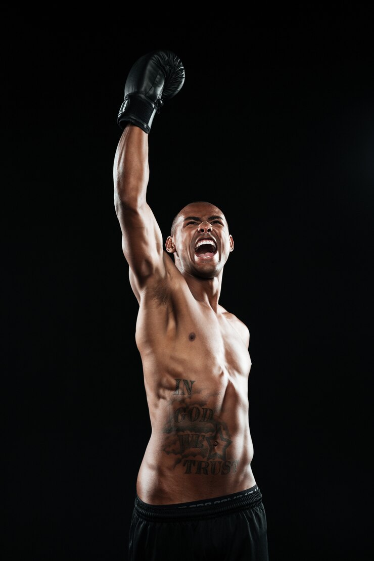 Free Photo young afro american boxer celebrating his victory with raised arm in black glove