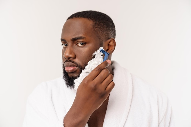 朝のコンセプトでバスルームの個人的な朝のルーチンの衛生で剃っている若いアフリカ系アメリカ人の男