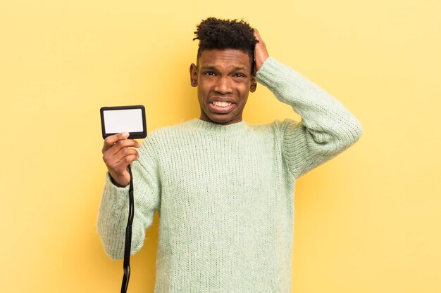 young afro man against yellow wall