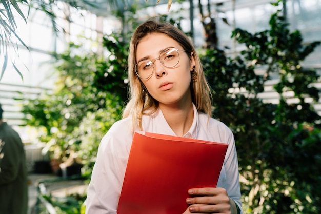 Young agricultural engineer working in greenhouse.