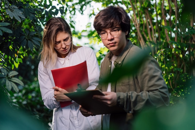 Free photo young agricultural engineers working in greenhouse