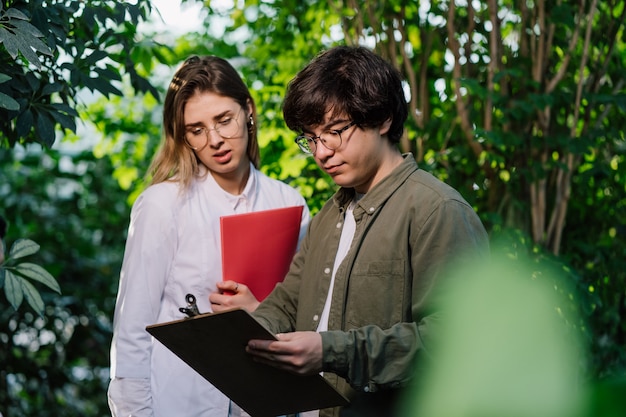 Young agricultural engineers working in greenhouse