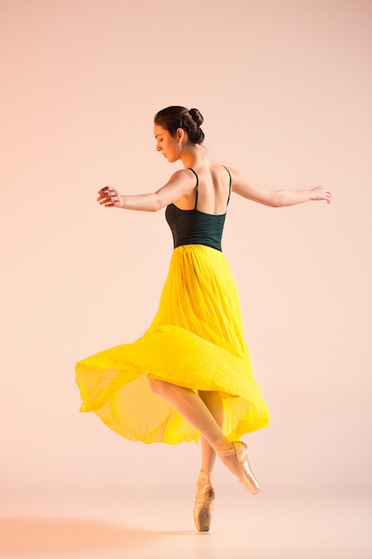 Бесплатное фото Молодая и невероятно красивая балерина танцует в студии