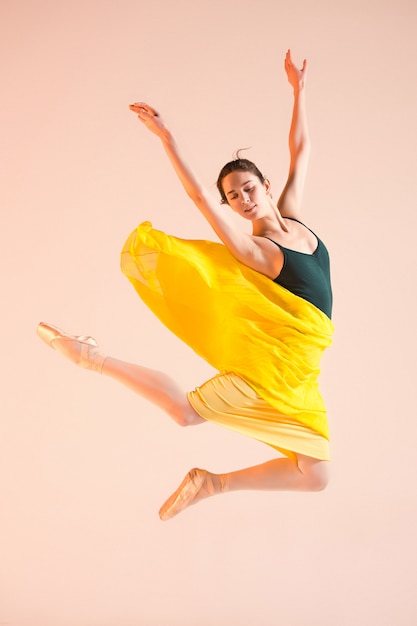 Бесплатное фото Молодая и невероятно красивая балерина танцует в студии