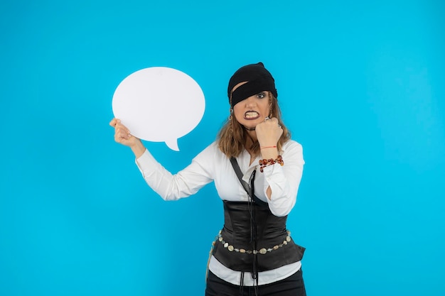 Young angry pirate girl holding white idea board. High quality photo