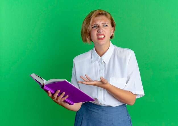 眼鏡をかけている好奇心旺盛な若いかわいい女子高生と本を持っているバックバッグは コピースペースで白で隔離された側を見てジェスチャーを聞くことができません 無料の写真