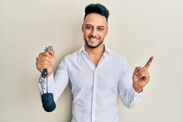 Free Stock Photo: Young Arab Man Smiling and Pointing with Hand and Finger to the Side