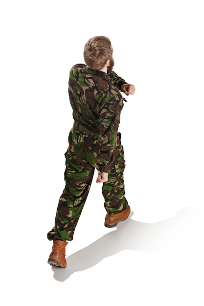 Foto gratuita giovane soldato dell'esercito che indossa l'uniforme del camuffamento isolata su bianco