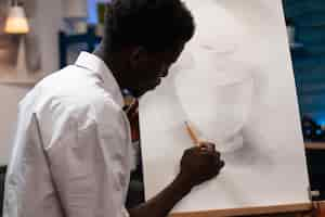 Free photo young artist drawing vase making shadows using professional graphic pencil working at creative ilustration for art lesson. concentrated man student painting on canvas sketching draw