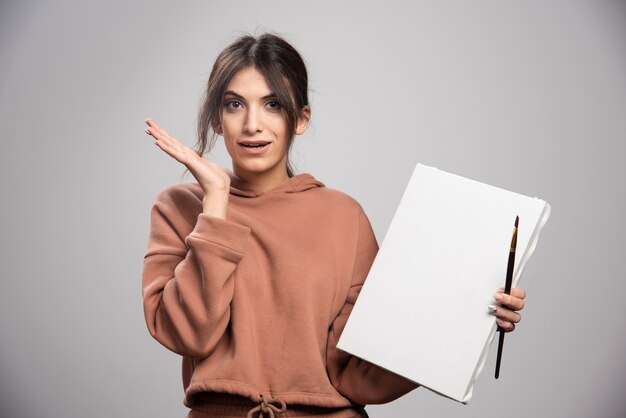 Young artist holding paint brush and canvas