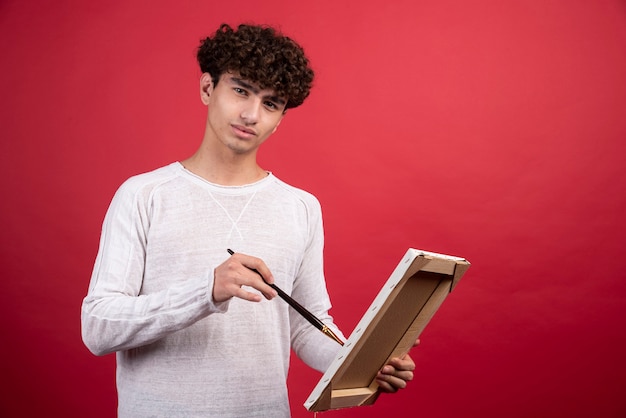 Young artist painting something on canvas