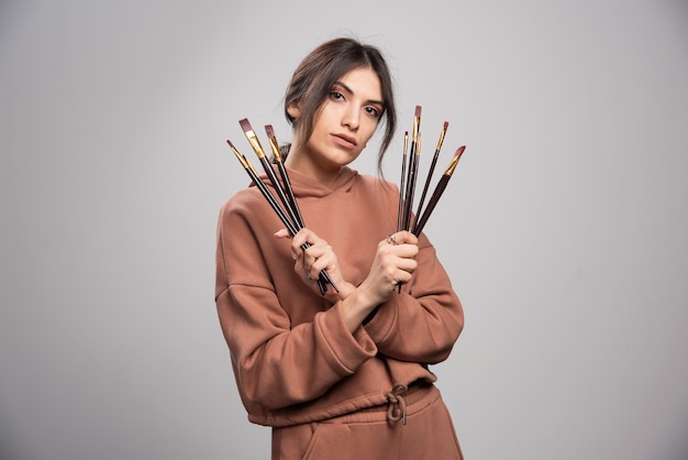 Young artist showing her black paint brushes