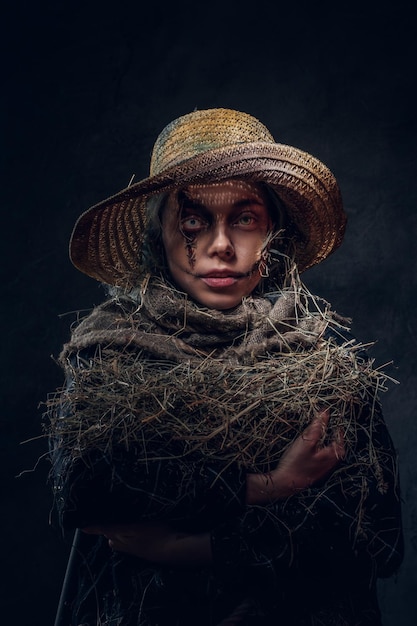 Young artistic woman is posing for photographer in a role of creepy scarecrow.