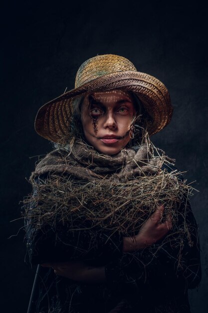 Молодая артистичная женщина позирует фотографу в роли жуткого чучела.