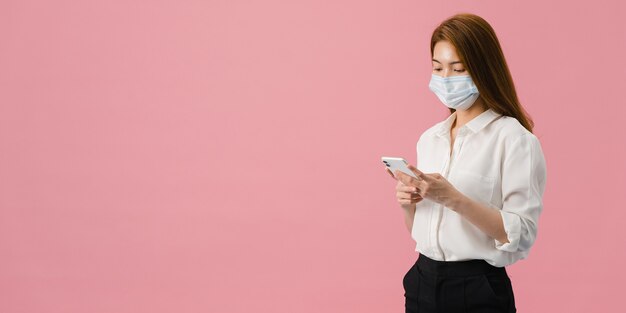 Young Asia girl wear medical face mask use mobile phone with dressed in casual cloth.