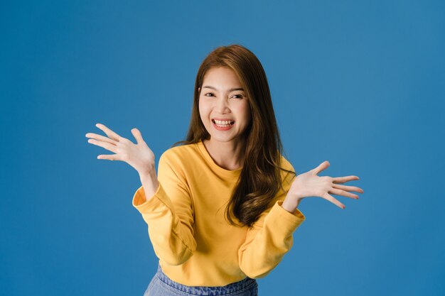 Young Asia lady feeling happiness with positive expression, joyful and exciting, dressed in casual cloth and looking at camera isolated on blue background. Happy adorable glad woman rejoices success.
