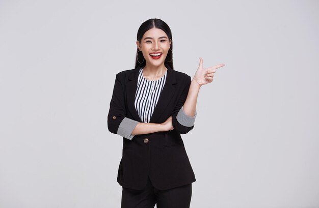 Young Asian business woman executive good looking and confidently while standing and pointing finger