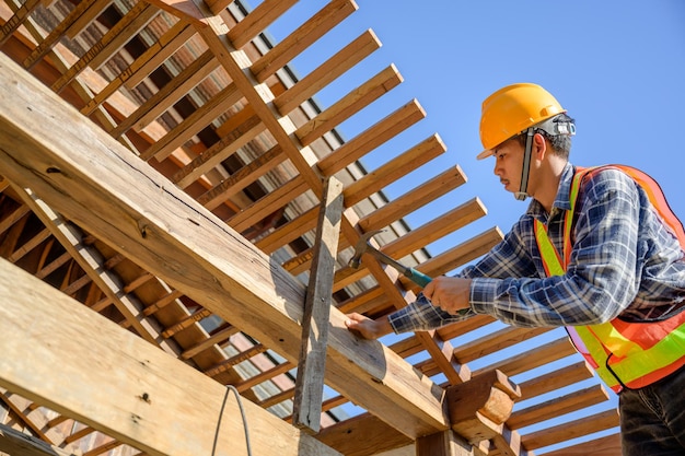 ワークショップ​で​働く​若い​アジア​の​大工​労働者​建設​現場​で​木造​住宅​の​屋根​構造​に​取り組んでいます​。