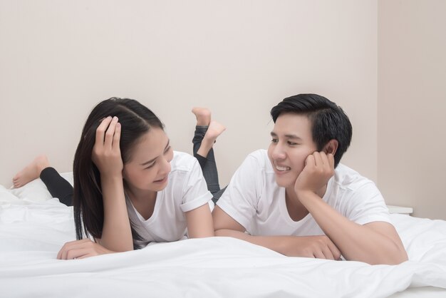 Young asian couple lying on bed