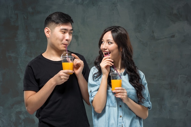 Young Asian couple with  glasses of Orange juice