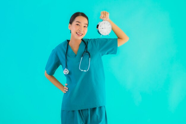 若いアジア医師女性は時計を示しています
