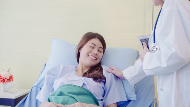 Young Asian doctor woman talking and holding hand for women patient in sick bed.