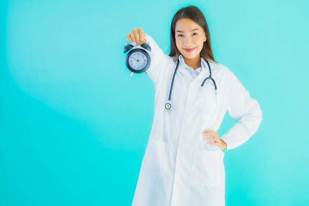 молодая азиатская женщина-врач с часами или будильником