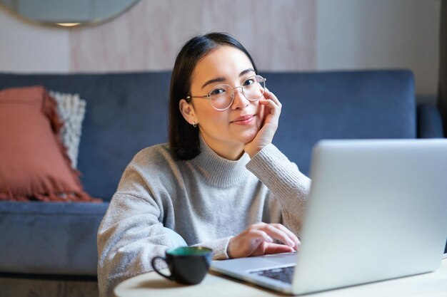 young asian girl freelancer professional sitting in living room and working with computer studying a