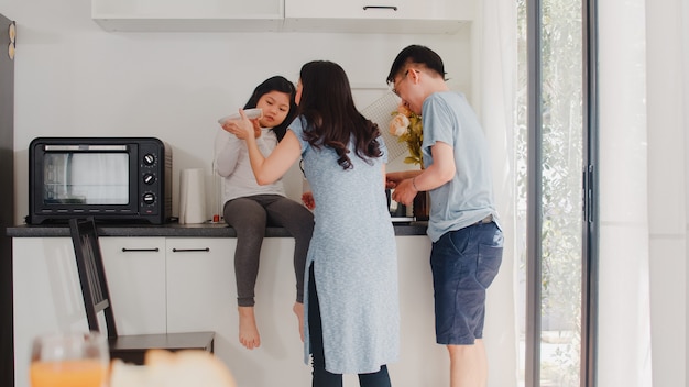 집에서 요리하는 젊은 아시아 일본 가족. 라이프 스타일 행복 엄마, 아빠, 딸 아침에 집에서 현대 부엌에서 아침 식사를 위해 파스타와 스파게티를 함께 만들기.