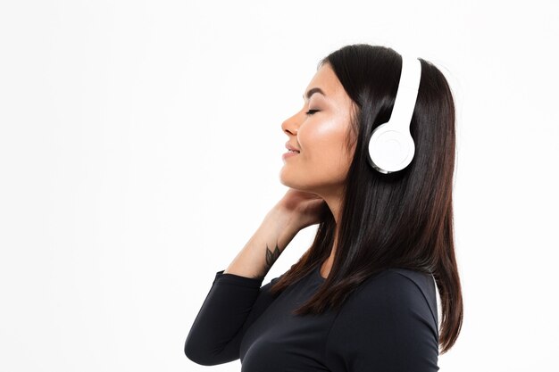Музыка молодой азиатской дамы слушая с наушниками