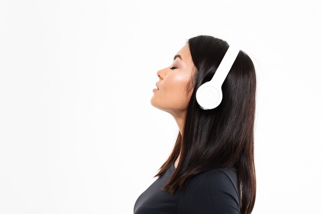 Музыка молодой азиатской дамы слушая с наушниками