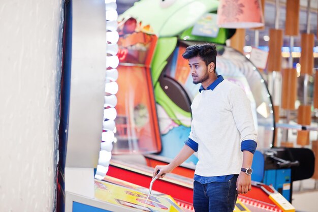 Young asian man play on fortune wheel slot machines to try win at lottery great prize