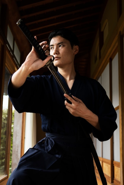 Young asian man with samurai sword