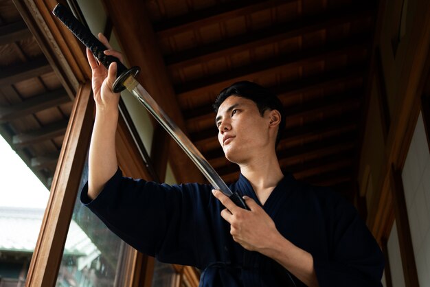 Young asian man with samurai sword