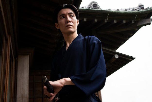 Foto gratuita giovane uomo asiatico con la spada del samurai